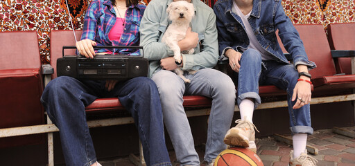 Friends enjoying a sunny day while holding a dog and a basketball