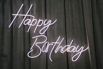 Bright birthday celebration sign lights up the room