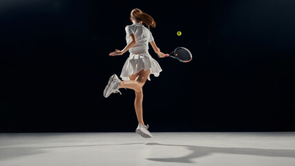 Young female athlete jumping with energy and joy during tennis training. Concept of education visuals, confidence growth through movement, coordination, and youth motivation.