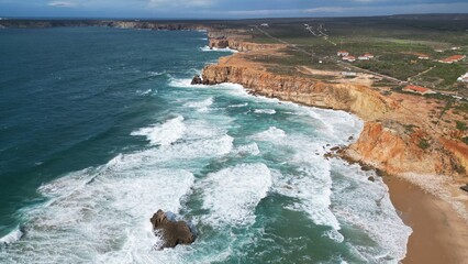 Rocky coastal cliff with natural arch in Faro, Algarve, Portugal