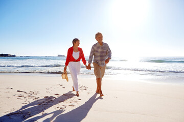 Love, travel and holding hands with couple at beach for summer vacation, romance and connection. Bonding, anniversary getaway and walk with mature man and woman outdoor for holiday, marriage and date