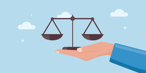 Hand holding scales of justice in a light blue sky setting