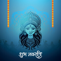 A stylized blue illustration of Goddess Durga's face with intricate details, framed by orange floral garlands, and a Shubh Navratri greeting below.