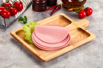 Sliced boiled sausage over board