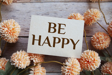 Be Happy Motivational and Inspirational quotes with flowers bouquet decoration on wooen background