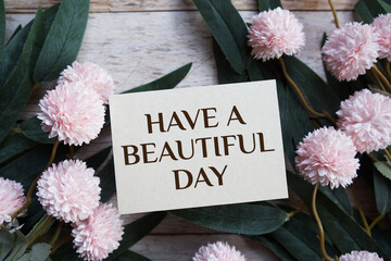 Have A Beautiful Day Motivational and Inspirational quotes with flowers bouquet decoration on wooen background