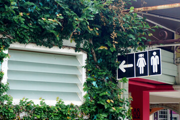 Toilet sign hanging beside window