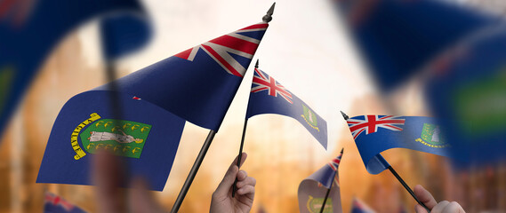 British Virgin Islands flags in their hands on a blurred urban background