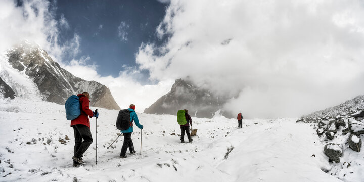 Group trekking on snowy trail in Baltoro Karakorum mountains Pakistan - Powered by Adobe