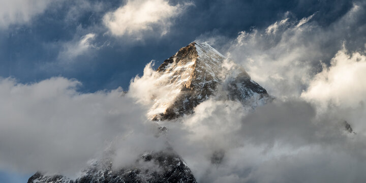 Dramatic view of K2 peak in Karakorum Pakistan with clouds and snow