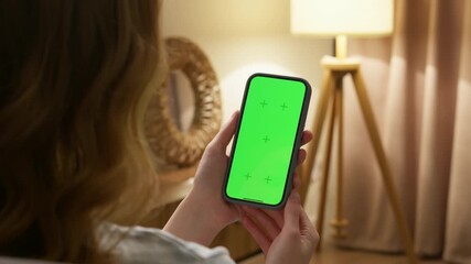 Woman use digital tech cell phone open green screen mock up. Hand press click phone web site middle center. Girl hold mobile. Turn on chroma key page. Cozy home background. Online app copy space.