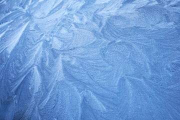 Frosty Patterns. Close-up of intricate frost designs on a blue surface,