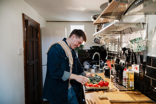 Man preparing a healthy meal in the kitchen with fresh vegetables