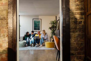 Family sitting on a sofa in the living room using a laptop together