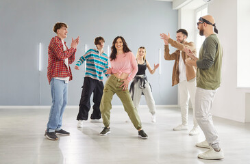 Cool dancer woman, group of dancing people dancing indoors, moving posing in studio space, dance class, rehearsal in dynamic pose, enjoying practicing or performing, community having fun together