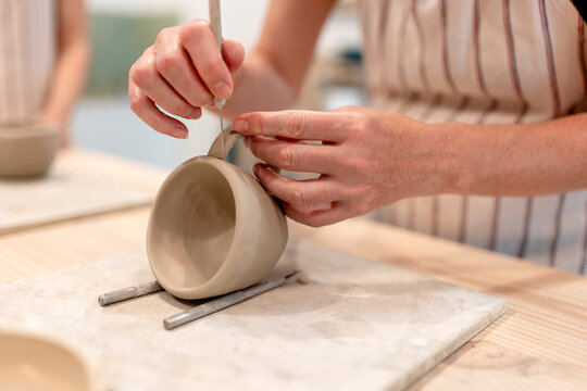 Smiling person shaping clay during pottery class workshop