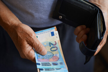 Hand holding euro banknotes and wallet representing finances and savings