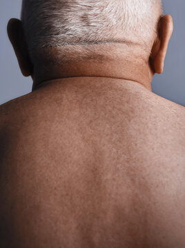 Rear view of elderly man with gray hair showing nape and upper back