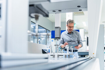 Engineer using tablet for precision measurement in modern industry