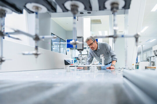 Engineer measuring machinery parts in modern industrial factory