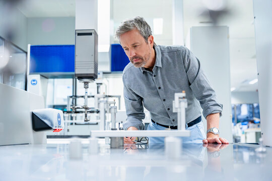 Engineer measuring and analyzing machinery in modern industrial lab