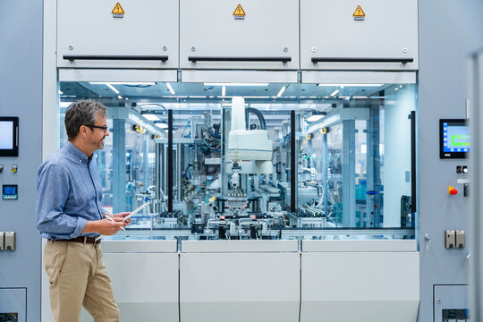 Engineer monitoring automated machinery in modern industrial facility - Powered by Adobe