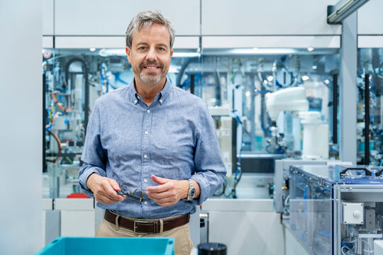 Engineer with industrial robots and machinery in modern factory