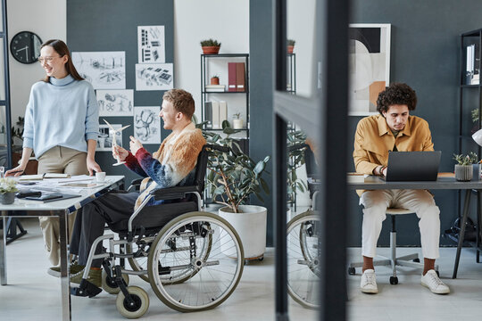 Manager attending meeting in room near employees at office