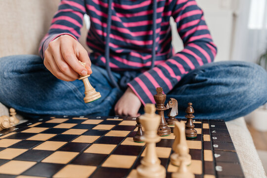 Close-up of hand holding chess queen piece making a strategic move