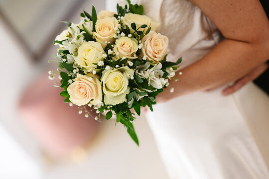 Bride holding wedding bouquet at celebration indoors