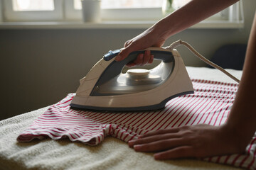 Ironing a striped shirt at home in morning light