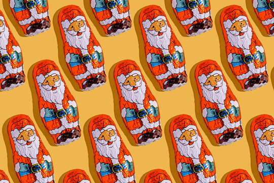 Santa Claus chocolates in a festive pattern on yellow background