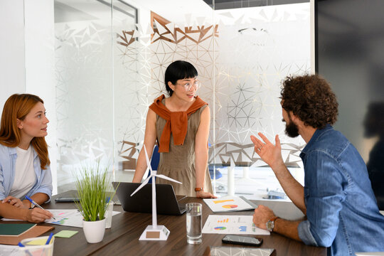 Team collaborating in modern office discussing renewable energy project