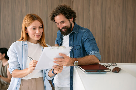 Business people signing and receiving document in office environment