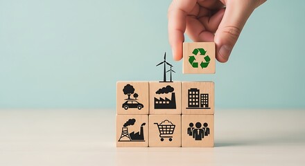 Hand placing a recycling symbol cube on top of blocks with ecofriendly icons, representing sustainability and green energy