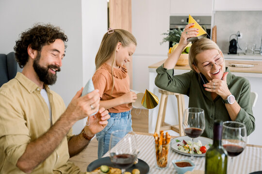 Family enjoying birthday celebration with food and laughter at home - Powered by Adobe
