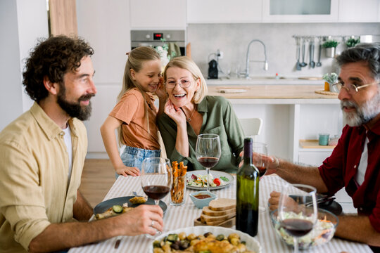 Family enjoying joyful mealtime and conversation indoors at home - Powered by Adobe