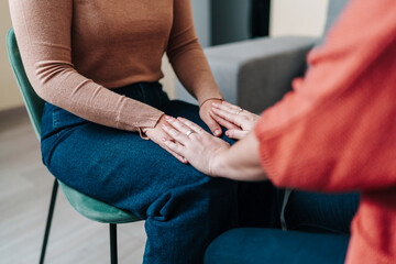Supportive coaching session with empathetic hand touch indoors