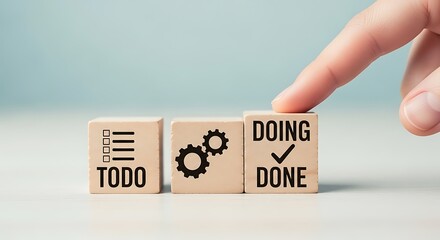 Fingers flipping wooden blocks from todo to doing to done, representing progress and task completion