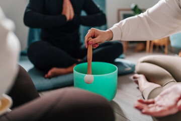 Group meditation and sound bowl healing session indoors with mindfulness