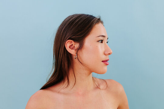 Side portrait with natural skin and clean beauty on blue background