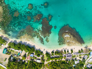 Island with a sandy white beach with palm trees and azure water and coral reef. Cagwait White Beach. Mindanao, Philippines. Travel and summer concept.