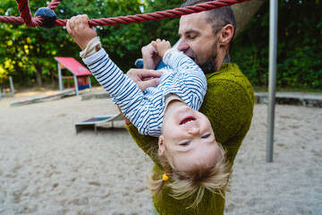 Father and daughter playing together on playground enjoying family time