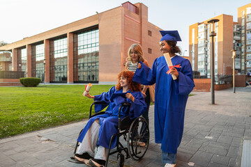 Graduates celebrating on campus with a mentor in a wheelchair