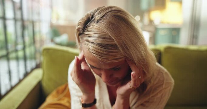 Headache, burnout or woman with stress in couch, exhausted or overwhelmed with brain fog. Migraine, frustrated or tired person with temple massage for relief in home, fatigue or overthinking for pain