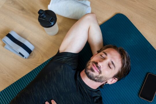Resting after morning stretch on fitness mat with relaxation and mindfulness