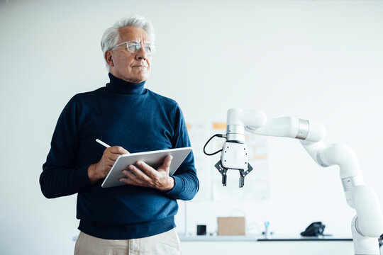Engineer working with a robot in a modern laboratory office