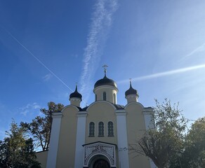 Berlin Germany October 2025 Facade of yellow Orthodox style church with three onion domes under blue sky
