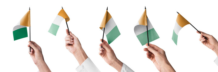 The Cote dIvoire flag in hand in different angles on a white background