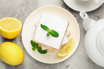 Tasty lemon bars with mint and fresh fruits on grey marble table, flat lay
